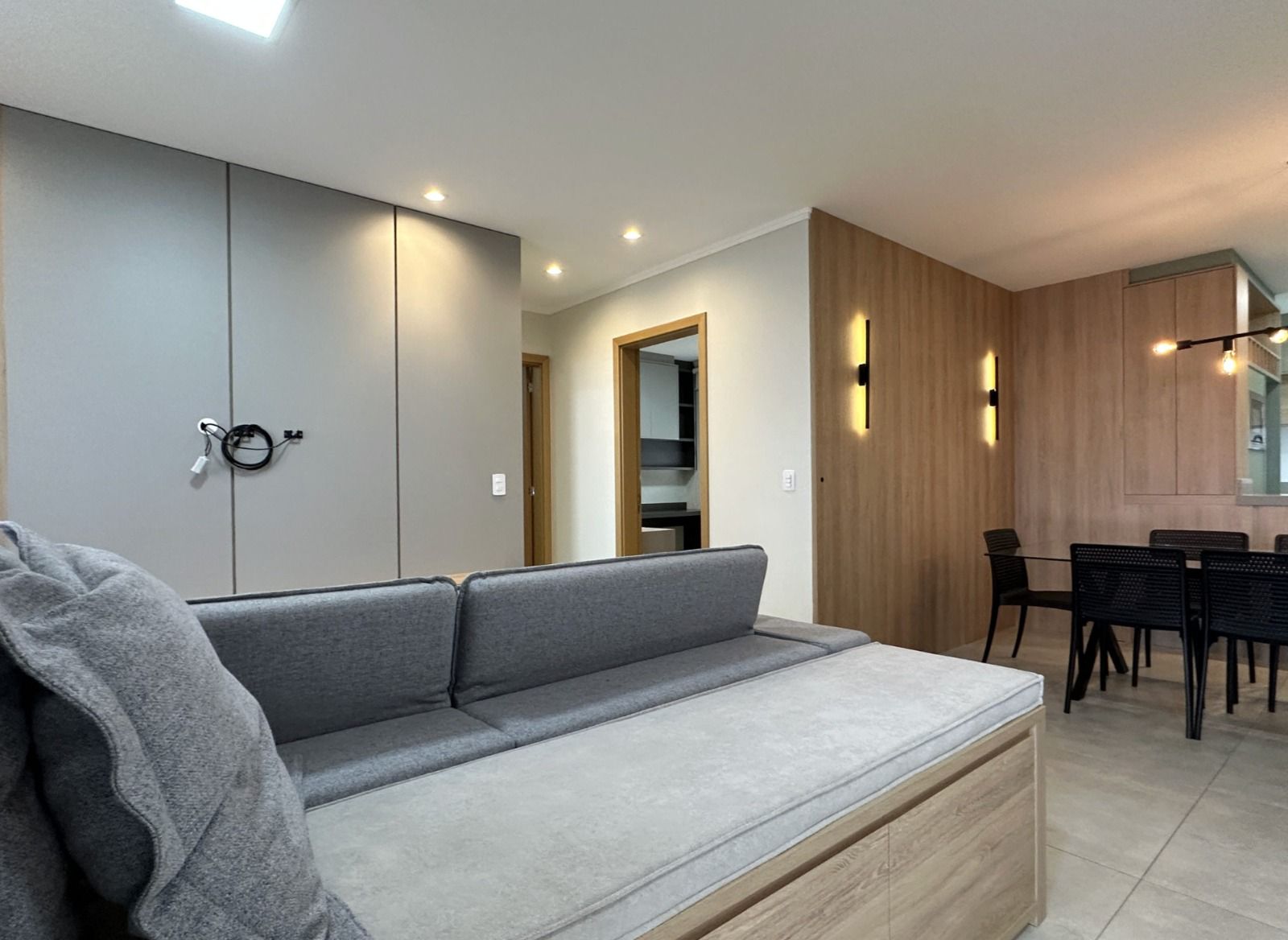 Sala de TV com sofá e cortinas